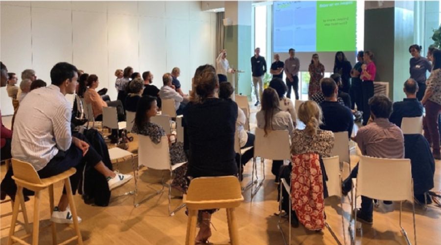 Atelier participatif avec des personnes assises en demi-cercle face à des intervenants